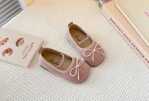 Close-up of stylish pink suede Mary Jane shoes for girls with cute bow detail and soft sole
