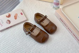 Elegant brown children's leather Mary Jane shoes featuring soft soles and adjustable buckle straps.