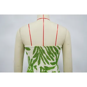 Vista dettagliata della stampa botanica verde e del retro a punto smock della tuta