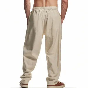 Detailed back view of men's loose beige linen trousers with an elastic waistband