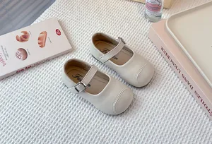 Detail view of cream children's Mary Jane shoes with adjustable buckle strap