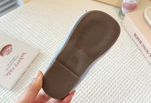 Detailed macro view of the non-slip brown rubber sole of a child's Mary Jane shoe