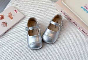 Close-up view of silver Mary Jane shoes for girls featuring buckle strap and soft soles