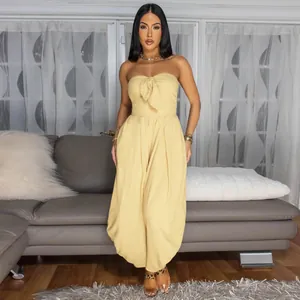 Elegant yellow strapless tube top jumpsuit with bow front detail worn by a model
