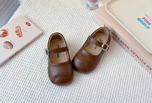 Detailed view of brown girl's Mary Jane leather shoes with adjustable silver buckle.