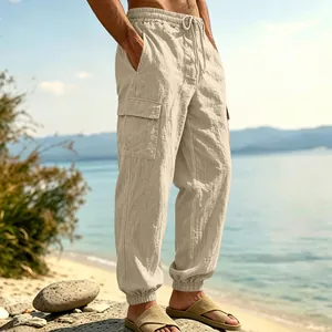 Close-up of men's linen cargo jogger pants showing texture and pockets in a beach setting