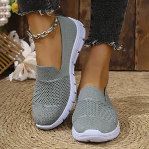 Vista detallada de zapatillas de malla gris transpirable con vaqueros informales