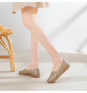 Close-up of comfortable khaki loafers for women worn on feet in a bright sunny room