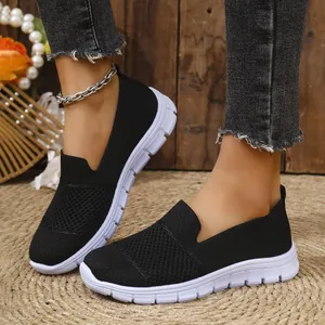 Primer plano de zapatillas sin cordones de malla negra transpirable para mujer con suela blanca