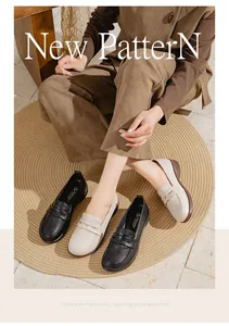 Close-up of comfortable flat leather loafers in black and beige displayed on a rug