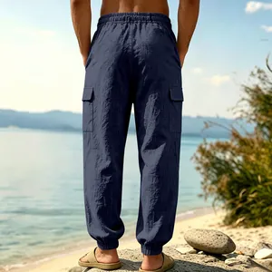 Rear view of men's navy linen cargo joggers on a scenic beach landscape