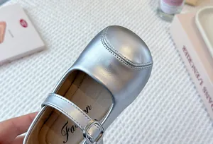 Close-up detail of silver girls princess flats showing soft texture and metallic finish.