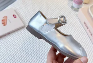 Close-up view of silver metallic girl's Mary Jane princess shoes with a buckle strap.