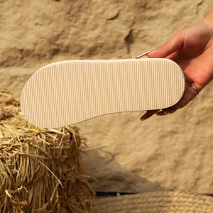 Gros plan de la semelle antidérapante à rayures d'une sandale plate d'été beige