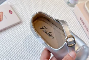 Close-up detail of silver metallic finish and buckle on soft sole girls Mary Jane shoes