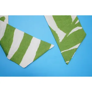 Dettaglio ravvicinato del tessuto stampato verde e bianco per una tuta slim-fit estiva