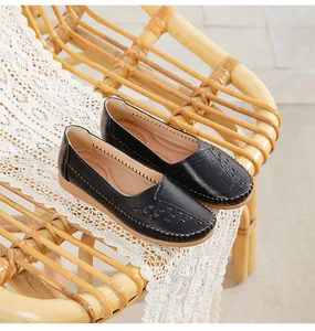 Comfortable black leather loafers for women displayed on a vintage bamboo chair with lace.