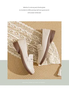 Detail view of comfortable beige flat loafers on aesthetic straw and lace background