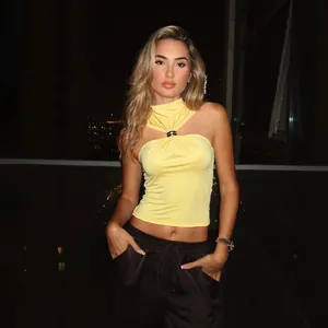Detailed view of yellow halter tank top with elegant metal ring decoration.