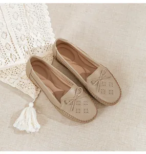 Detail view of beige women's breathable loafers with laser-cut floral pattern and bow.