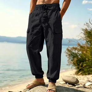Detail view of men's black linen cargo pants with multi-pockets and drawstring waist