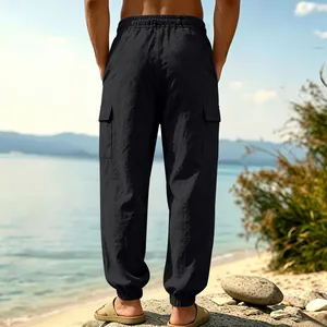 Back view of black linen cargo joggers for men in a relaxed outdoor beach setting
