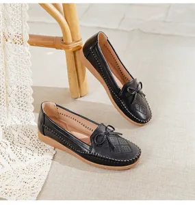 Detailed view of black breathable flat loafers with bow decoration and hollow pattern