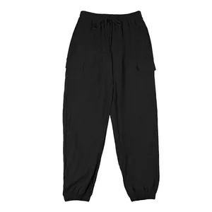 Detail view of black men's linen cargo pants with drawstring waist and pockets.