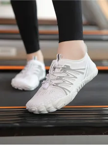 A detailed view of white quick-dry barefoot wading shoes worn on an indoor treadmill