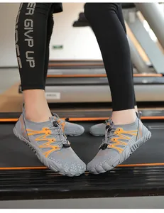 Close-up action shot of grey quick-dry wading shoes with orange accents on a treadmill