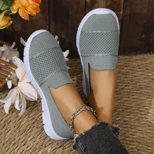 Vista dettagliata delle scarpe slip-on in mesh grigio traspirante con suola bianca