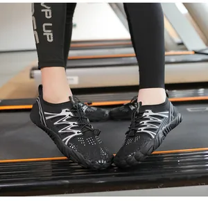 Close-up of lightweight black quick-dry water shoes with adjustable laces on a treadmill