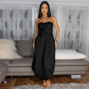 Full length detail of a stylish black strapless jumpsuit featuring a front bow tie detail
