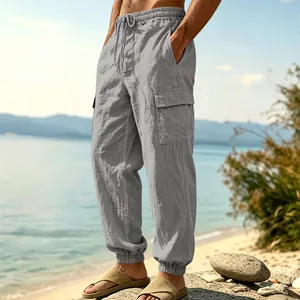 Men's loose fit linen cargo pants with multi-pockets and elastic cuffs for beach leisure.