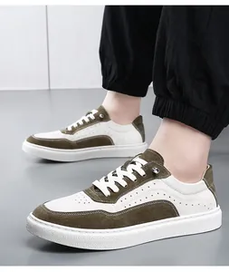 Gros plan de baskets rétro pour hommes en cuir blanc et vert olive portées par un modèle
