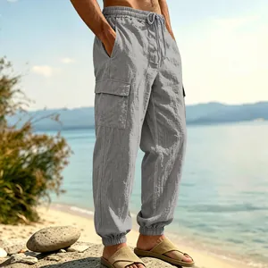 Loose fit men's linen cargo jogger pants with side pocket shown in a sunny beach setting