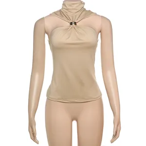 Detail shot showing the metallic gold ring ornament on a beige halter neck tank top