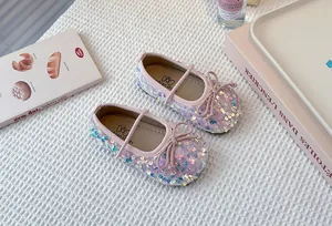 Detailed view of sparkly pink sequined girls' princess shoes with an elegant bow accent