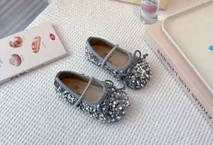 Detailed macro view of silver sequined girl's ballet flats with an elegant bow detail