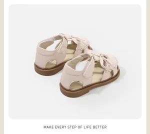 Rear view of pink baby girl sandals with decorative bow and scalloped edges