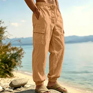 Detail view of men's loose linen cargo pants with multiple pockets and elastic cuffs