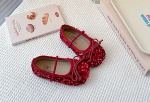 Close-up detail of shiny red sequins and delicate bow on soft sole girls princess shoes