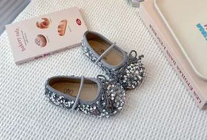 Detailed macro view of silver sequin children's Mary Jane princess shoes with elegant bow accent