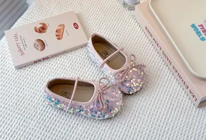 Close-up detail of pink iridescent sequin Mary Jane flats for girls with bow accents.