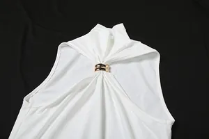 Detail view of a white halter neck top featuring a golden metal ring and pleated neckline.