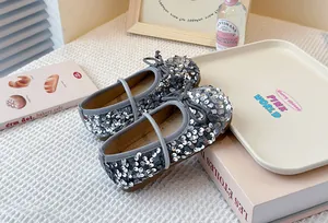 Elegant close-up of sparkling silver sequin Mary Jane shoes for girls with bow detail