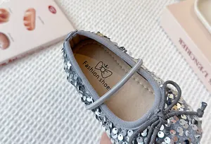 Close-up detail of silver sequined girls' princess shoe with bow and soft insole