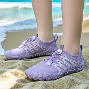 Purple quick-dry water shoes for outdoor beach sports on sand with ocean background