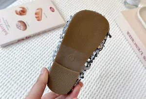 Detailed macro view of non-slip rubber sole with size 23 on silver sequin girls shoes
