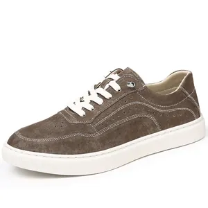 Vue latérale de baskets en daim marron avec semelles blanches épaisses et lacets
